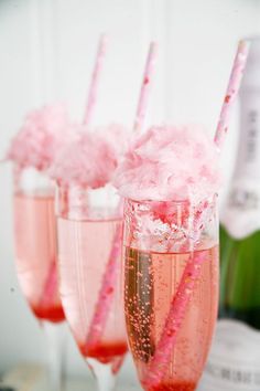 three glasses filled with pink liquid and straws