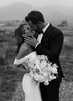 a bride and groom kissing in the desert