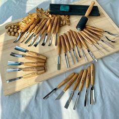 a wooden cutting board topped with lots of knives