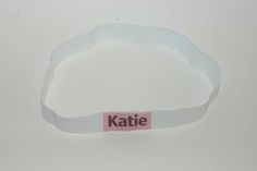 a white wristband with the word kate on it and a pink tag attached to it