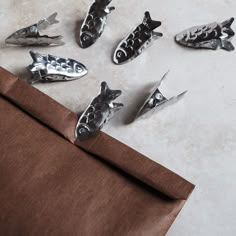 six metal fish on top of a brown bag