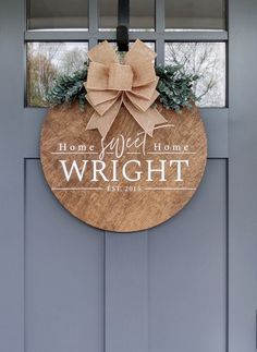 a wreath is hanging on the front door of a home with a sign that says, home sweet home wright