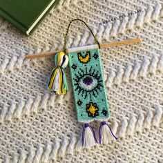 a bookmark with a tassel hanging from it's side on a table