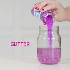 a person is pouring colored liquid into a jar with the word glitter on it and an image of a woman's hand