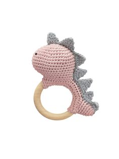 a crocheted pink and gray dinosaur teethpick on a wooden toy ring