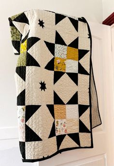 a black and white quilt hanging from the side of a door with stars on it