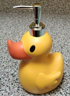 a yellow rubber ducky soap dispenser sitting on a granite countertop