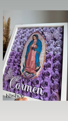 an image of the virgin mary surrounded by purple roses in a white box that says carmel