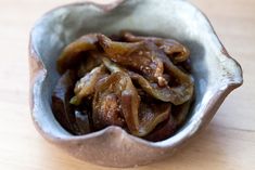 a small bowl filled with cooked food on top of a wooden table