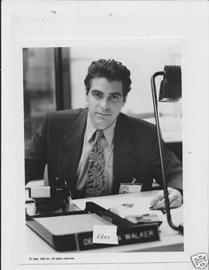 black and white photograph of man in suit sitting at desk