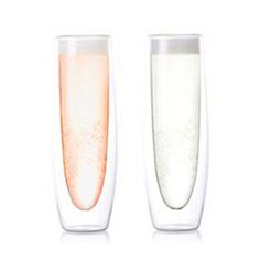 two champagne flutes filled with liquid sitting next to each other