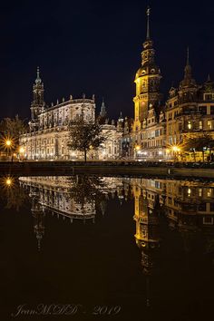 an image of a city at night with lights reflecting in the water and buildings on both sides