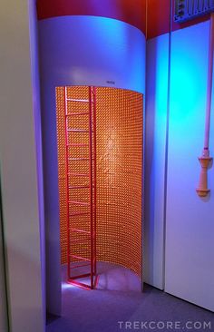 an orange and blue room with a ladder in it