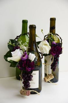 two wine bottles with some flowers in them