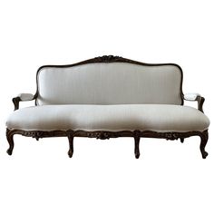 an antique style couch with white upholstered fabric