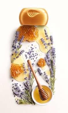 honey and lavenders on a plate next to a jar of honey with a wooden spoon