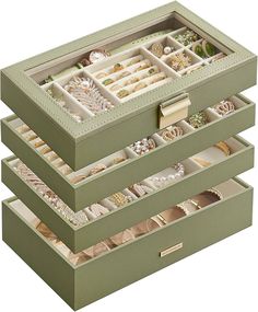 three green boxes filled with lots of different types of jewelry on top of each other