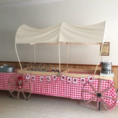 an old fashioned wagon with red and white checkered tablecloth