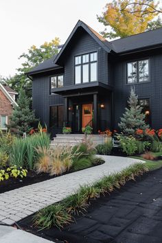 a black house with lots of windows and landscaping