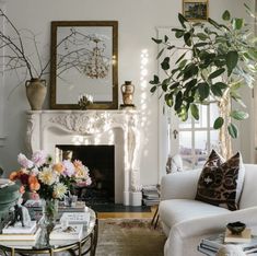 a living room filled with furniture and a fire place in front of a white fireplace