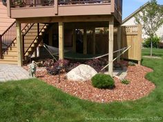 a house with a hammock in the front yard and stairs leading up to it