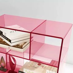 a pink shelf with books and other items on it