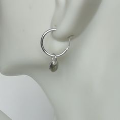 A PAIR of sterling silver hoops. Comes with a detachable tiny and delicate round disc charm. The charm is multipurpose and can be used with a neck or bracelet chain too. Dimension: Hoop- 12x1.2 mm Charm- 5 mm Drop length- 17 mm Price listed is for ONE PAIR These are made of 925 hypoallergenic sterling silver. Most of my pieces come with a 925 stamp. Can be packaged in a gift box. I can include a personal message from you if needed You are welcome to contact me at... bhavnakwintra1956@gmail.com F Minimalist Metal Round Huggie Earrings, Minimalist Round Metal Huggie Earrings, Modern Nickel Free Round Cartilage Earrings, Modern Nickel-free Round Cartilage Earrings, Minimalist Metal Small Hoop Huggie Earrings, Minimalist Charms Huggie Earrings For Everyday, Everyday Hoop Earrings With Charms, Minimalist Huggie Dangle Earrings With Charms, Minimalist Metal Round Cartilage Earrings