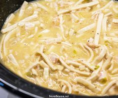 chicken noodle soup in a crock pot on top of the stove, ready to be cooked