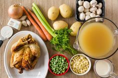 an assortment of food including chicken, peas, carrots and broccoli on a table