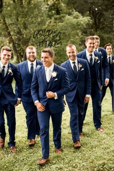 a group of men standing next to each other on top of a lush green field