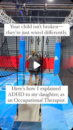 a woman in grey shirt standing on top of a blue and red gym floor with ropes