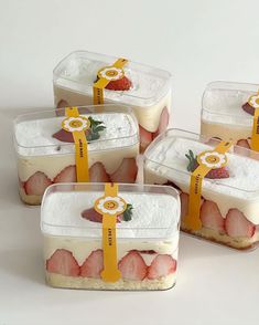 four plastic containers filled with food on top of a white table