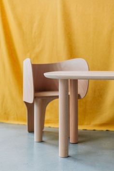 a wooden table and chair sitting next to each other on top of a cement floor