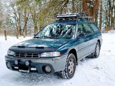 a car parked in the snow with its roof rack mounted on it's top