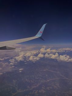 the wing of an airplane flying over clouds