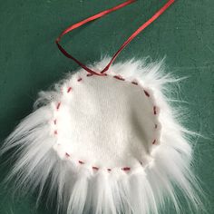 a white ornament hanging from a red string