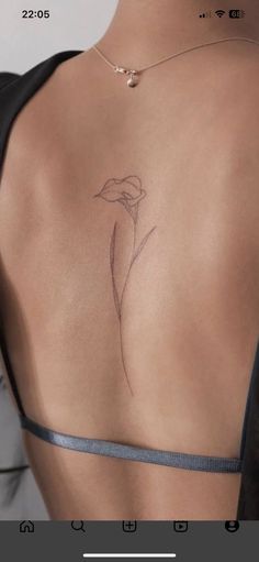 a woman's back with a flower tattoo on it