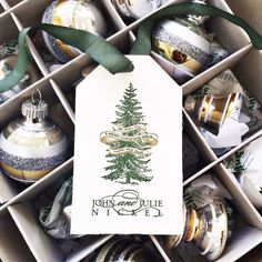 an open box filled with christmas ornaments and a white tag hanging from the top of one ornament