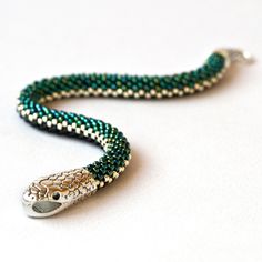 Adorn your wrist with our beaded snake bracelet. Symbolic snake jewelry for meaningful, reptile-inspired style. Dazzling Serpent Elegance: Handcrafted snake bracelet Sparkling beads, eye-catching design A striking statement piece 🐍 Embrace the Wild Side 🐍: Bold snake skin print Unleash your inner reptile lover Unique accessory for fearless fashion Perfect Gift for Reptile Enthusiasts: Ideal for snake enthusiasts Thoughtful reptile lover's gift Show your passion for serpents This bracelets (or necklace) is made of highest quality Japanese Toho beads. Diameter 0.3 inches (0.7 cm). IMPORTANT: When choosing the length of the bracelet, keep in mind that the bracelet should be about 1 inch longer than your wrist. Bracelet is 100 % handmade. Green Snake Jewelry, Luxury Snake-shaped Bracelet As Gift, Beaded Snake Bracelet, Ouroboros Jewelry, Cobra Bracelet, Beaded Snake, Serpent Bracelet, Snake Choker, Necklace Snake