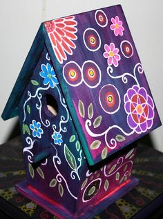 a painted birdhouse sitting on top of a table