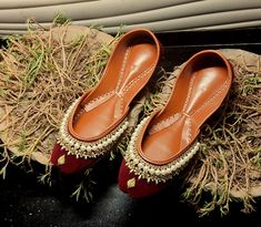 Zur-4 is a Maroon base khussa, jutti, mojari handmade with quintessential exemplary of pleasant, luxurious and traditional artistry. These are the adorable heritages of Pakistan that are hand-sewed by determined cordwainers of rural areas to exhibit the utmost beauty of prepossessing feet. Diwali Reception Flats, Meenakari Wedding Flats, Wedding Traditional Wear With Cutdana, Traditional Wedding Flats For Navratri, Wedding Flats For Diwali With Closed Toe, Festive Wedding Flats With Cut Dana, Festive Cut Dana Flats For Wedding, Punjabi Jutti Wedding, Golden Lace