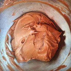 a bowl filled with chocolate frosting on top of a table