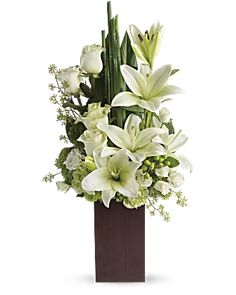 white flowers and greenery in a brown vase