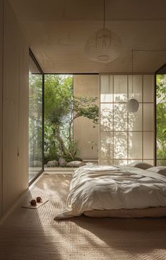 a bed sitting in the middle of a bedroom next to a wall with windows on it