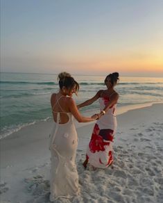 two women on the beach holding hands