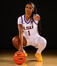 a woman kneeling down with a basketball in her hand