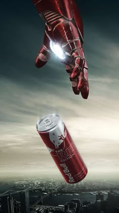 an iron man can flying through the air next to a hand with a light on it