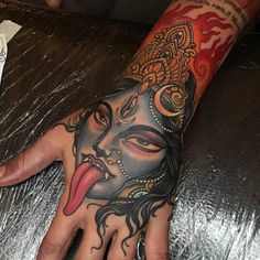 a person's hand with a tattoo on it and an image of a mask