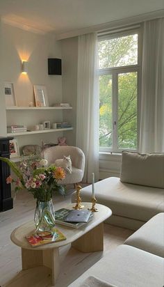 a living room filled with furniture and a fire place in front of a large window