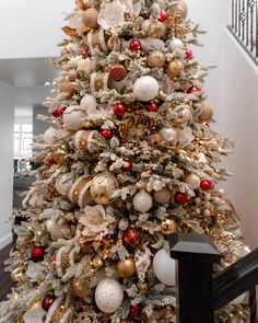 a white christmas tree with red and gold ornaments